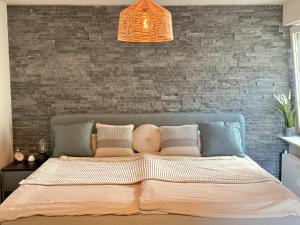 a bed in a bedroom with a brick wall at JUPAS - Premium Apartments Trier in Trier +33 photos