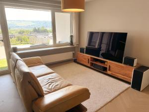 a living room with a couch and a flat screen tv at JUPAS - Premium Apartments Trier in Trier