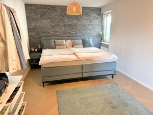 a bedroom with a bed with a brick wall at JUPAS - Premium Apartments Trier in Trier