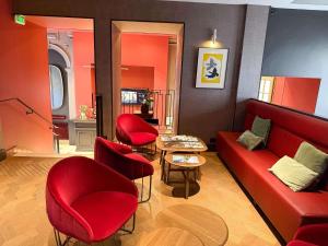 a living room with red chairs and a red couch at Mercure Rennes Centre Place Bretagne in Rennes