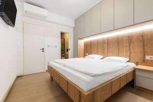 a bedroom with a large bed with a wooden headboard at Andrea Deluxe Apartment with Pool in Mali Lošinj +39 photos