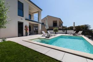 a swimming pool in the backyard of a house at Andrea Deluxe Apartment with Pool in Mali Lošinj