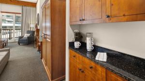 a kitchen with a counter top and a living room at 147 Studio Spruce Peak Lodge at Stowe Mt Resort Sleeps 4 in Stowe