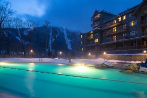 a swimming pool in front of a building at night at 147 Studio Spruce Peak Lodge at Stowe Mt Resort Sleeps 4 in Stowe