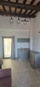 a living room with a couch and a kitchen at Dimora del Cammino di Cancellara in Foligno