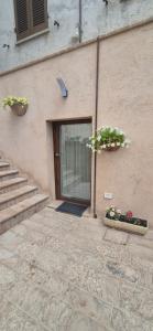 a door to a building with two potted plants on it at Dimora del Cammino di Cancellara in Foligno