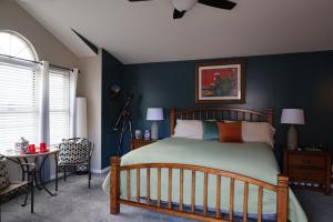 a bedroom with a bed and a blue wall at Harvest House Inn in Springdale
