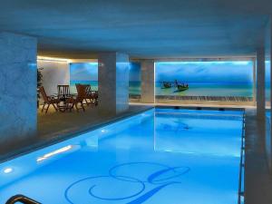 a swimming pool in a house with a view of the ocean at Sofitel Beirut Le Gabriel in Beirut