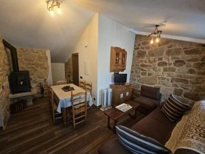 a living room with a table and a stone wall at El Lagar de Mailusa in Sayar