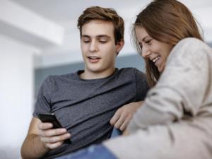 a young man and woman looking at a cell phone at ibis budget Berlin Hoppegarten in Hoppegarten