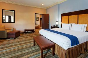 a hotel room with a large bed and a chair at Holiday Inn Express Benicia by IHG in Benicia +39 photos