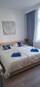 two blue pillows on a large bed in a bedroom at Rab Apartments Žic in Kampor
