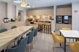 a restaurant with tables and chairs and a kitchen at TownePlace Suites by Marriott San Pablo in San Pablo