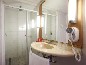 a bathroom with a sink and a shower with a mirror at ibis Buenos Aires Congreso in Buenos Aires