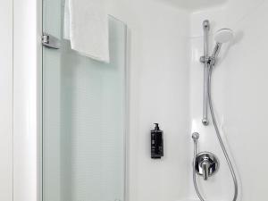 a shower stall with a glass door with a shower at ibis Hotel Würzburg City in Würzburg +55 photos