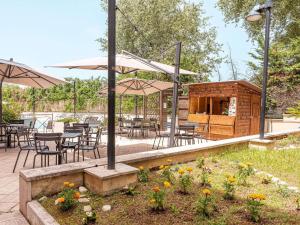 a patio with tables and chairs and umbrellas at Novotel Roma Est in Rome