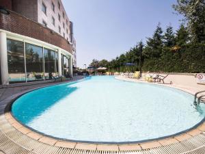 a large swimming pool in front of a building at Novotel Roma Est in Rome