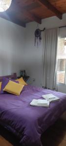 a purple bed with two books and a keyboard on it at Árbol de Oro - Terrafirme in Villa Yacanto +27 photos