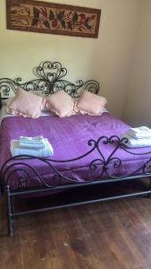 a bed with a purple blanket and pillows on it at Casale Santilli in Agnone +17 photos