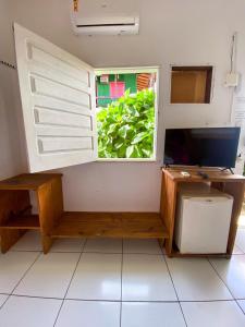 a window in a room with a desk and a computer at Pico das Praias Suites in Itacaré