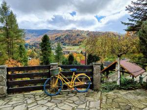a yellow bike parked against a fence in the mountains at Family Relax Widoki in Szczyrk