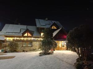 a house with christmas lights on it in the snow at Family Relax Widoki in Szczyrk