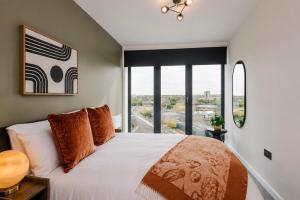 a bedroom with a large bed with a large window at City Penthouse - Roof Terrace & Free Parking in Beeston Hill