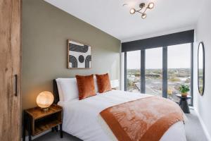 a bedroom with a bed and a large window at City Penthouse - Roof Terrace & Free Parking in Beeston Hill