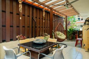 a patio with a table and chairs and a swing at Casa Villa Ensueño in Jacó