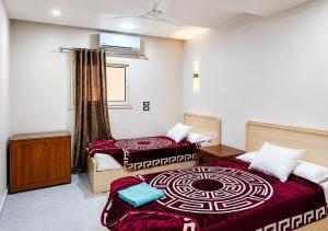 a bedroom with two beds and a window at Gannet Alyousef City Center in Naj‘ al Maḩaţţah