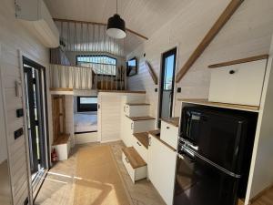 a kitchen in a tiny house with a black refrigerator at Tiny House WICA in Königs Wusterhausen