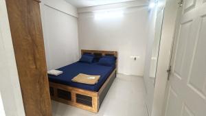 a small bedroom with a bed with blue sheets at Stay near to temple 240m in Guruvāyūr