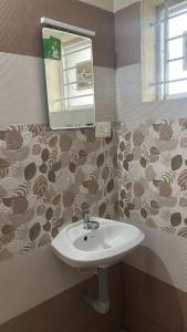 a bathroom with a sink and a mirror at Stay near to temple 240m in Guruvāyūr +3 photos