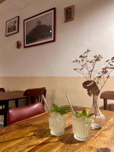a wooden table with two white vases on it at Auberge des Veillees in Blesle