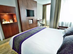 a hotel room with a large bed and a television at Mercure Alameda Quito in Quito