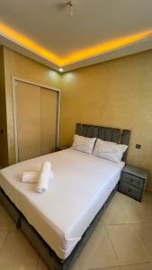 a bedroom with a bed with white sheets and pillows at Appartement Agadir in Inezgane