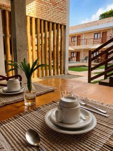 a table with plates and spoons on a wooden table at Pousada Don Ruan in Tutóia