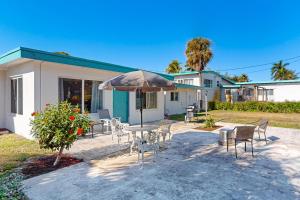 a patio with a table and chairs and an umbrella at 4 Mi to Beach! Lake-View Florida Family Retreat in JFK Medical Center Incorporated Heliport