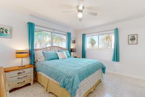 a bedroom with a bed and two windows at 4 Mi to Beach! Lake-View Florida Family Retreat in JFK Medical Center Incorporated Heliport