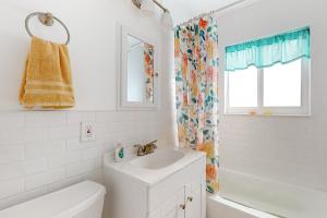 a white bathroom with a sink and a shower curtain at 4 Mi to Beach! Lake-View Florida Family Retreat in JFK Medical Center Incorporated Heliport +23 photos