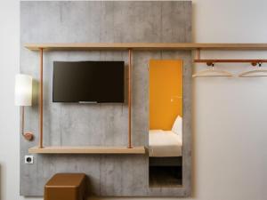 a room with a tv on a wall at ibis Budget Charleroi Airport in Charleroi