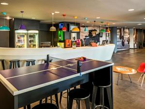 a ping pong table in a bar with stools at ibis Sao Paulo Interlagos in São Paulo