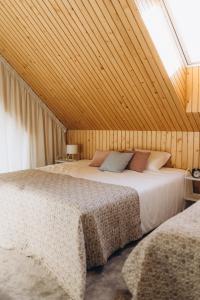 two beds in a room with a roof at Projekt Babia - Domek z jacuzzi in Lipnica Wielka