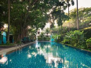 a large swimming pool with trees and blue water at Mercure Surabaya Grand Mirama in Surabaya