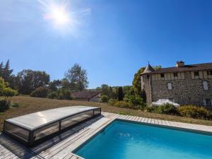 a swimming pool with a bed next to a house at Château de la Moissetie in Aurillac