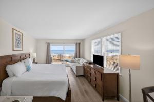 a bedroom with a bed and a couch and a television at Ocean Surf Resort in Montauk +88 photos