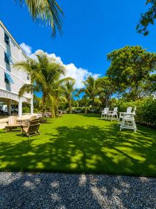 a yard with chairs and palm trees next to a building at Ocean Pointe Resorts - Serenity 2308 in Tavernier