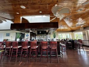 a bar in a restaurant with wooden ceilings and red stools at Ocean Pointe Resorts - Serenity 2308 in Tavernier