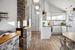 a kitchen with white cabinets and a brick wall at 1005-Thisted-Spanggardsvej-39 in Torsted
