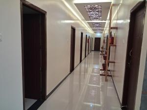 a hallway with doors and mirrors in a building at Saravana Residency in Allinagaram